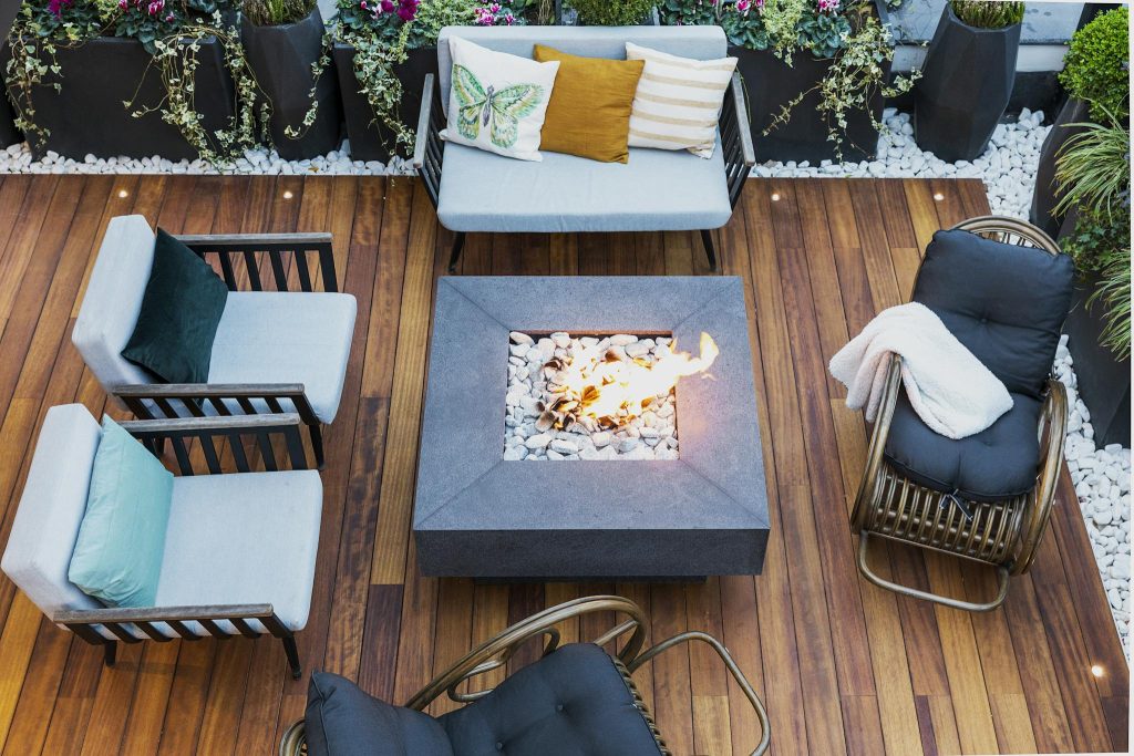 A top-down view of a modern patio featuring stylish furniture and a central firepit.